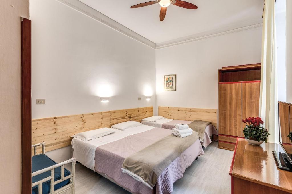 a bedroom with two beds and a ceiling fan at Hotel Altavilla 9 in Rome