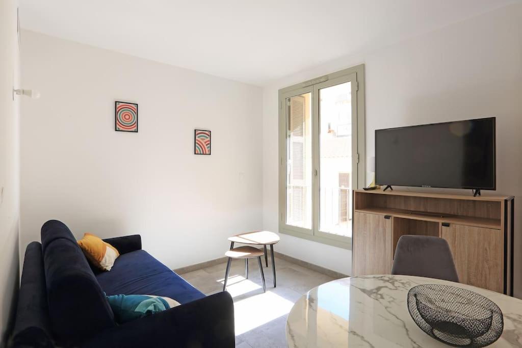 un salon avec un canapé bleu et une télévision dans l'établissement Citadella confort moderne au centre de Calvi, à Calvi