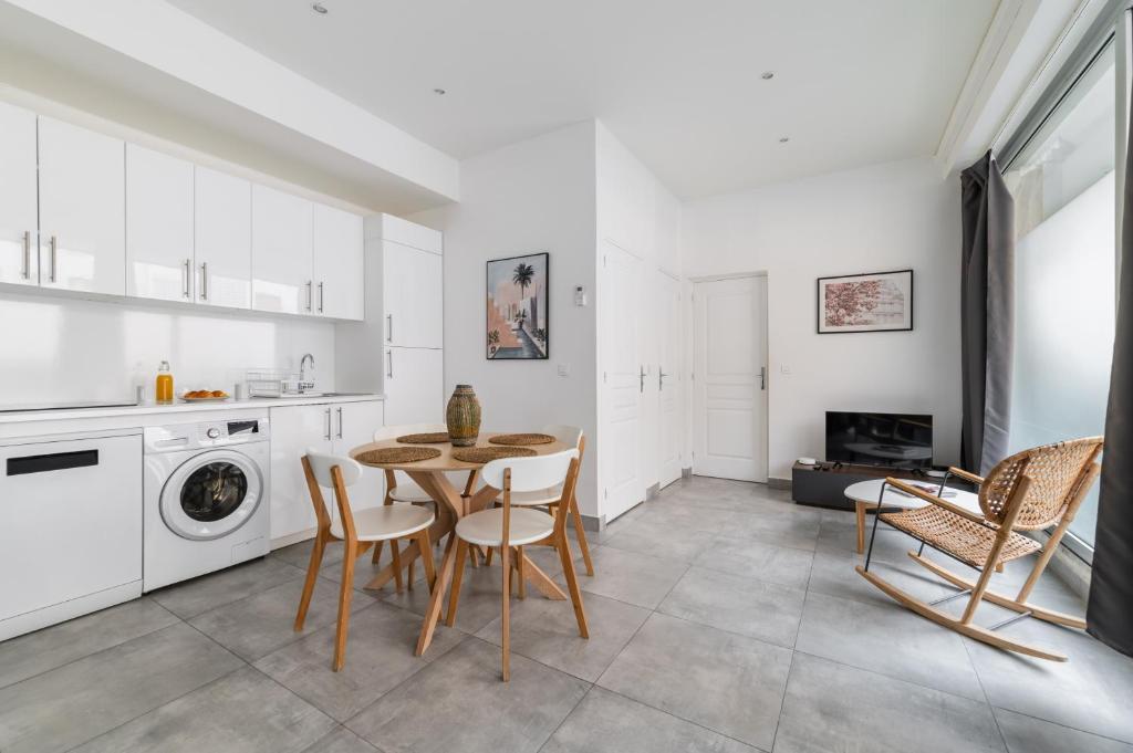 une cuisine et une salle à manger avec une table et des chaises dans l'établissement Charmant appartement calme place du Trocadéro - 4P - FLAT-GUEST, à Paris