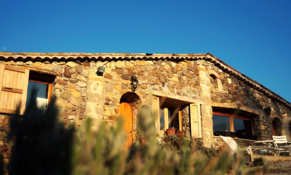 una antigua casa de piedra con una puerta naranja en Gîte Studio Saint Ribert, en La Rochette