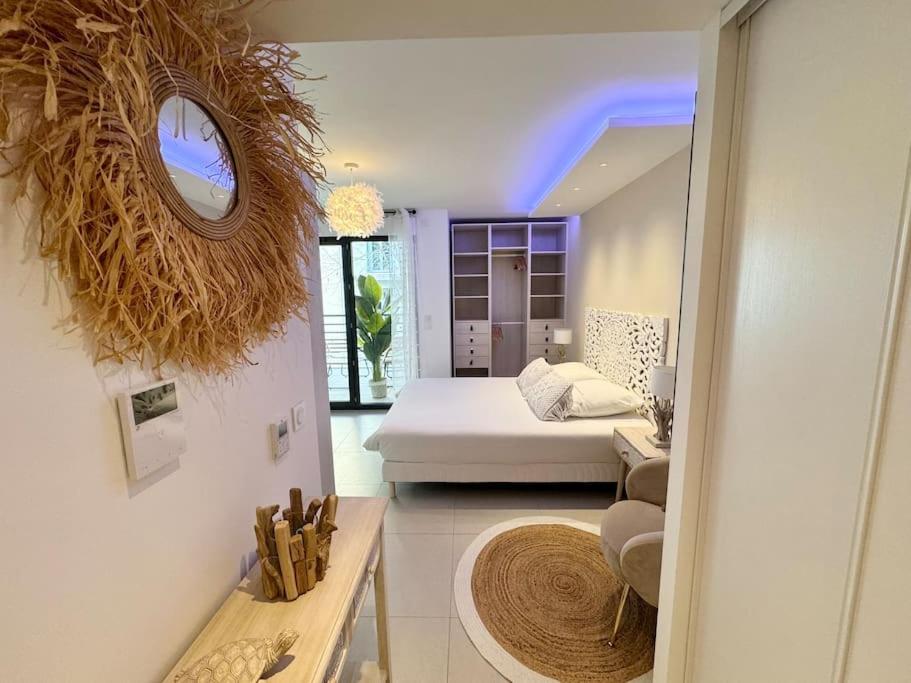 a living room with a bed and a room with a mirror at Magnifique studio bohème neuf cœur de ville in Antibes
