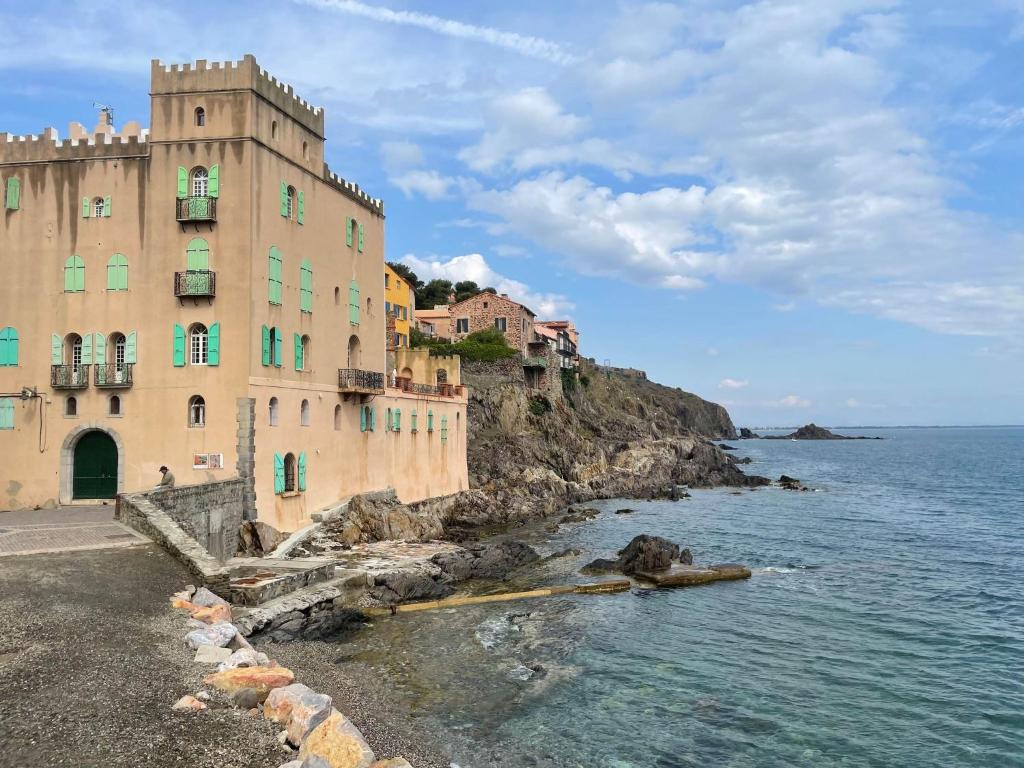 a building on a cliff next to the ocean at 5RBUT1 - Maison familiale sur deux niveaux en plein coeur du centre ville in Collioure