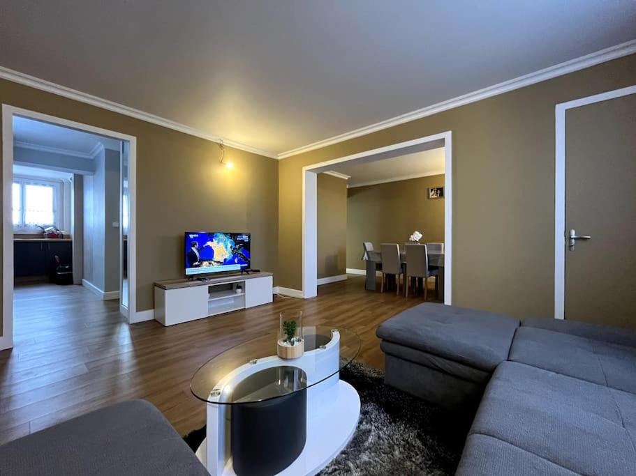 een woonkamer met een bank en een tv bij Familial Apartment - Troyes in Troyes