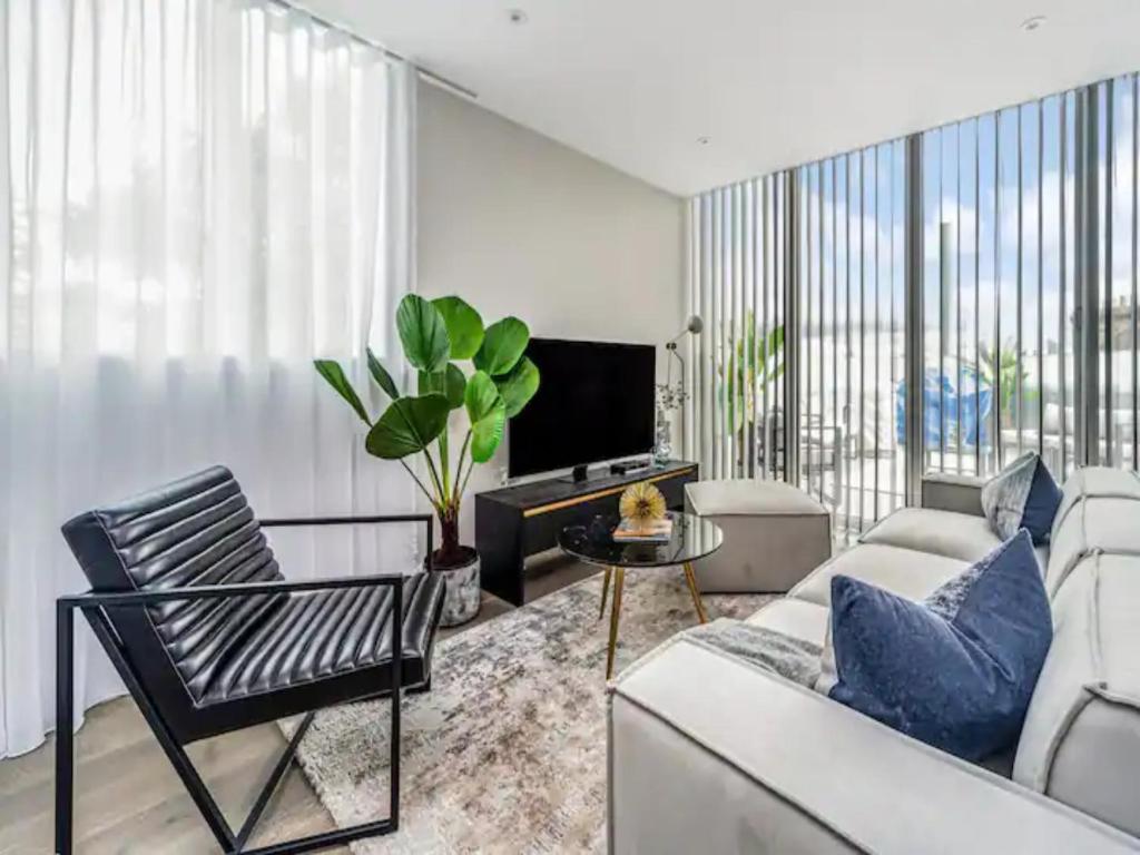 a living room with a couch and a tv at Pass the Keys Modern 2-BR Penthouse Oasis Ideal for Business Family and Group Retreats in Trendy Fulham in London