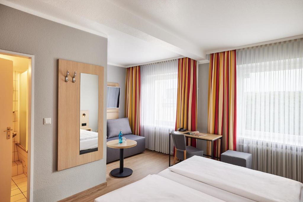 a hotel room with a bed and a table at Hotel Central Hamburg in Hamburg