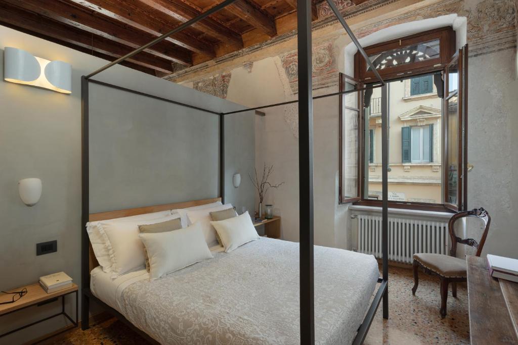 a bedroom with a canopy bed and a window at Residenza Roccamaggiore in Verona