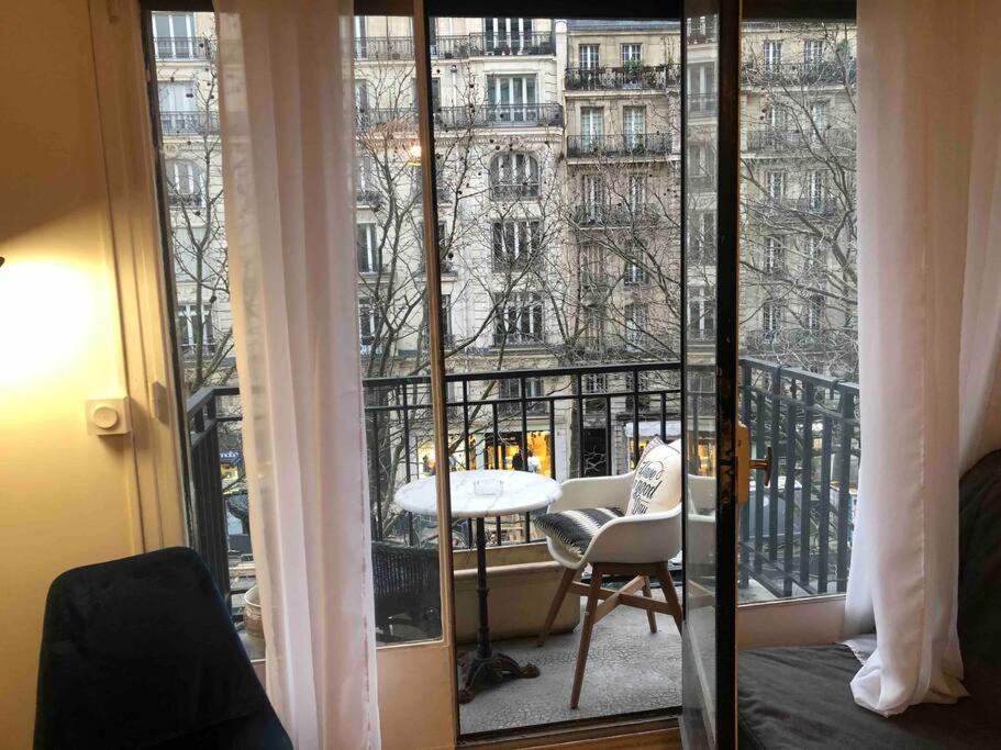 a room with a balcony with a view of a building at Grand appartement proche métro in Paris