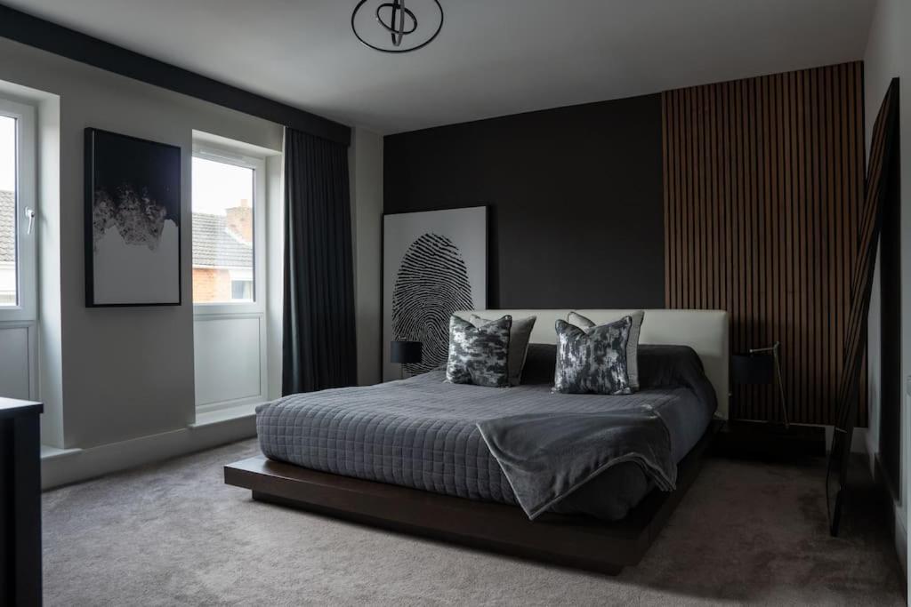 a bedroom with a bed and a clock on the wall at Luxury Worcester Townhouse - Free Parking in Henwick