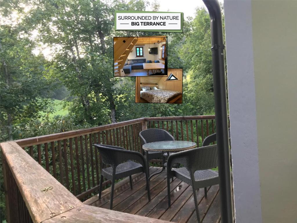 a balcony with chairs and a table and a sign at Apartma Povlč in Poljane nad Škofjo Loko