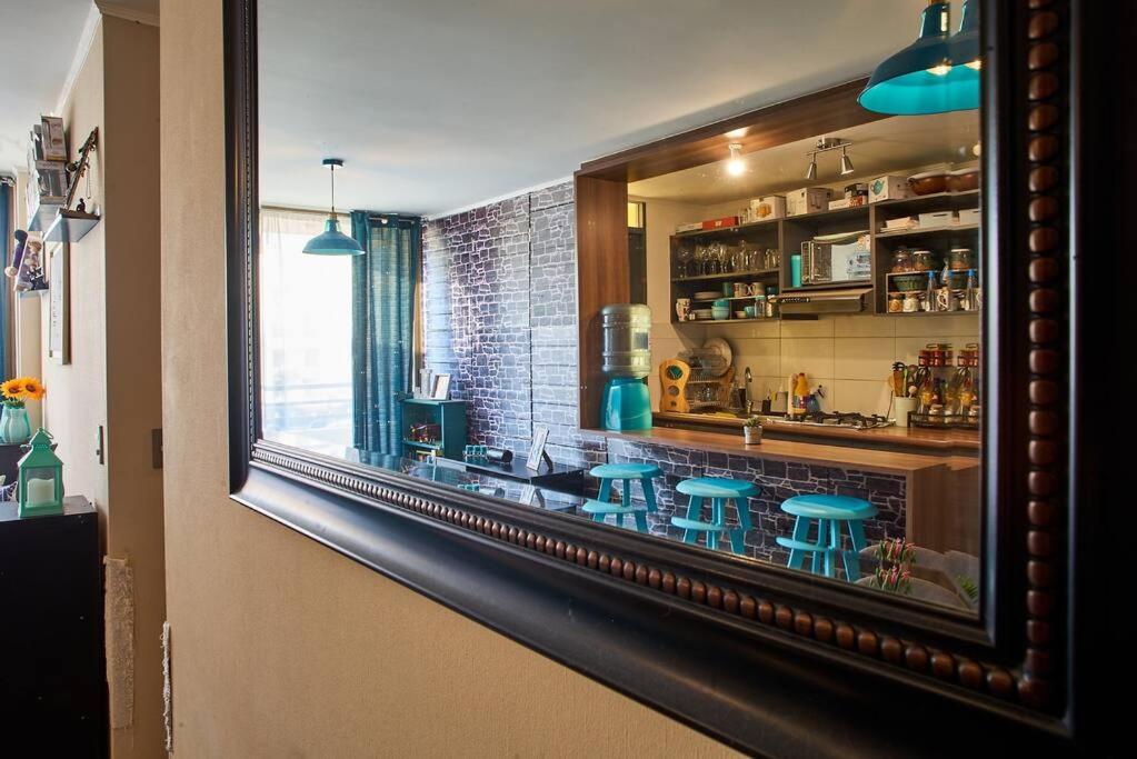 a reflection of a kitchen with stools in a window at Departamento amoblado en arriendo in Arica