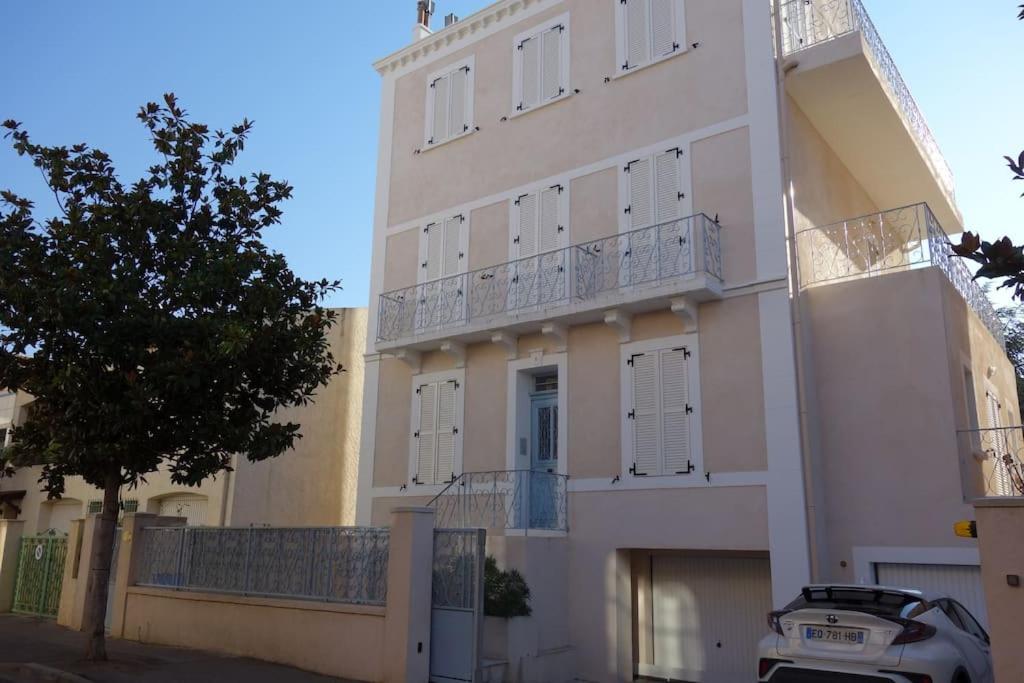 a white building with a balcony on the side of it at Appartement port de Sanary in Sanary-sur-Mer