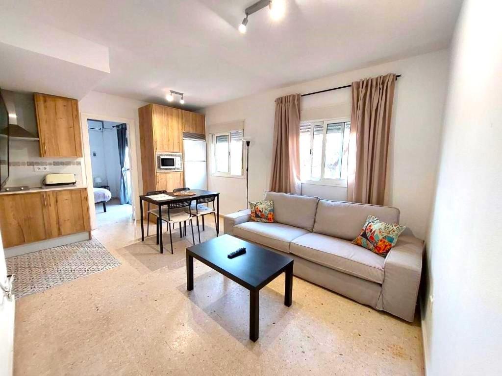 ein Wohnzimmer mit Sofa und Tisch in der Unterkunft Fray Isidoro Apartment in Sevilla
