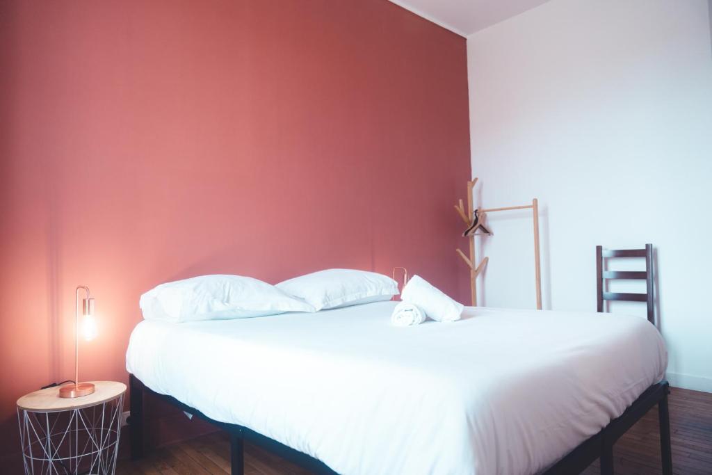 a bedroom with two beds and a red wall at Le Ronsardien - Appartement calme et confortable in Tours