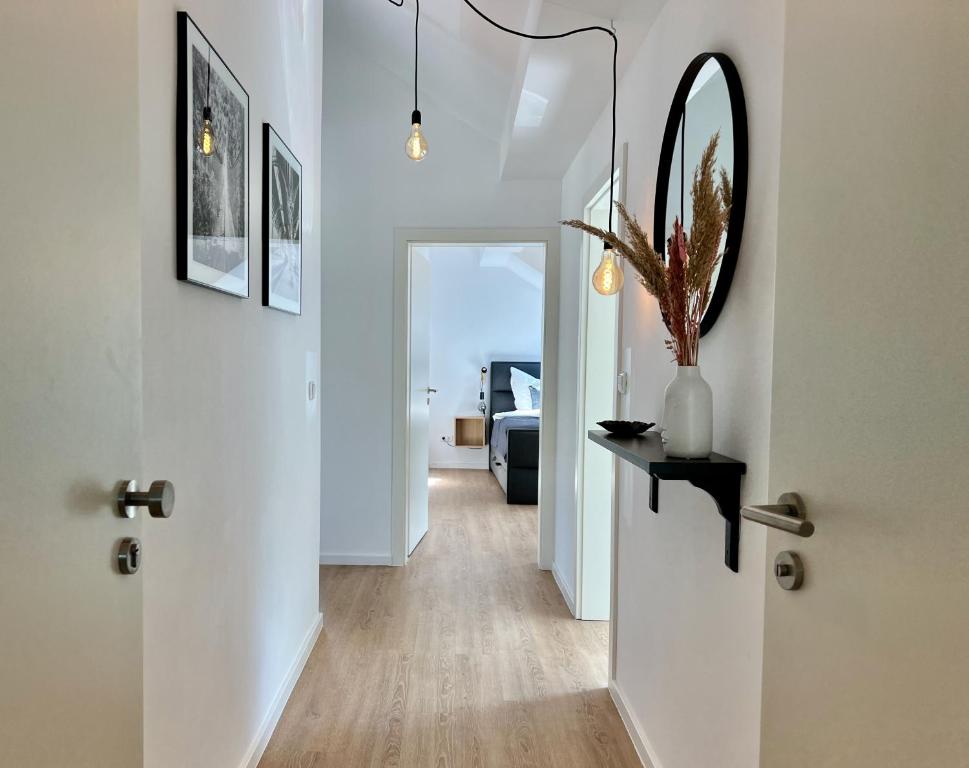 een hal met een witte deur en een spiegel bij VonMos Loft Apartment in Bernkastel-Kues