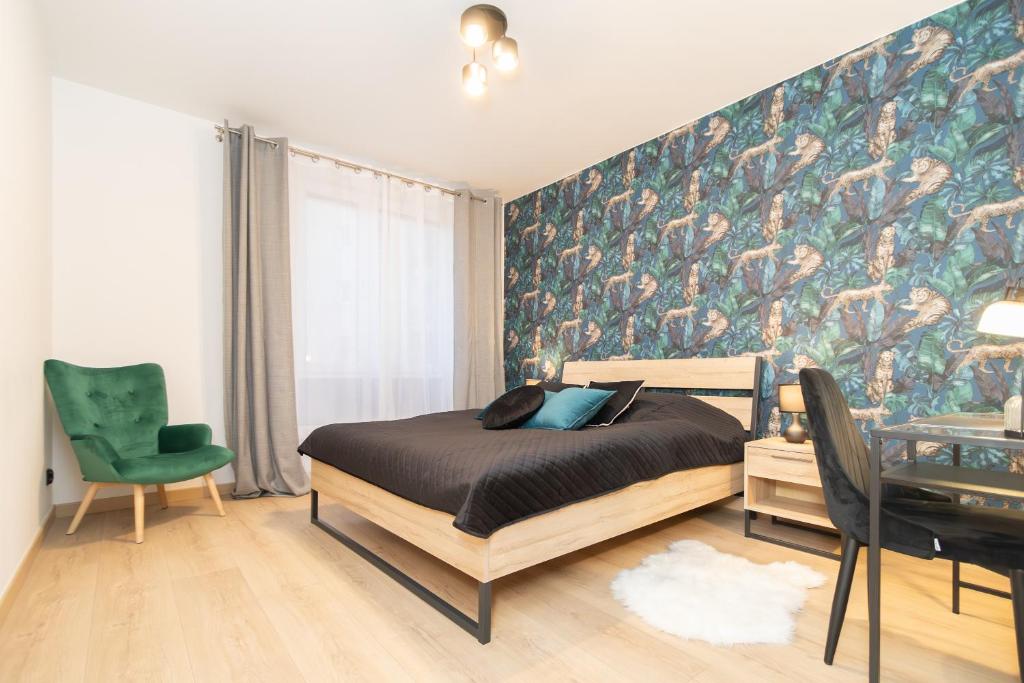 een slaapkamer met een bed en een muur met groene accenten bij Glow Apartments, Apartament Luna Śródmieście in Gdańsk