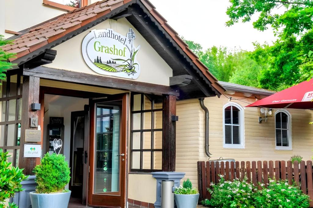 un restaurant avec un panneau à l'avant d'un bâtiment dans l'établissement Landhotel Grashof, à Mittelkalbach