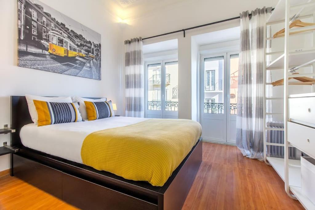 リスボンにあるParaíso Alfamaのベッドルーム1室(黄色い毛布付きのベッド1台付)
