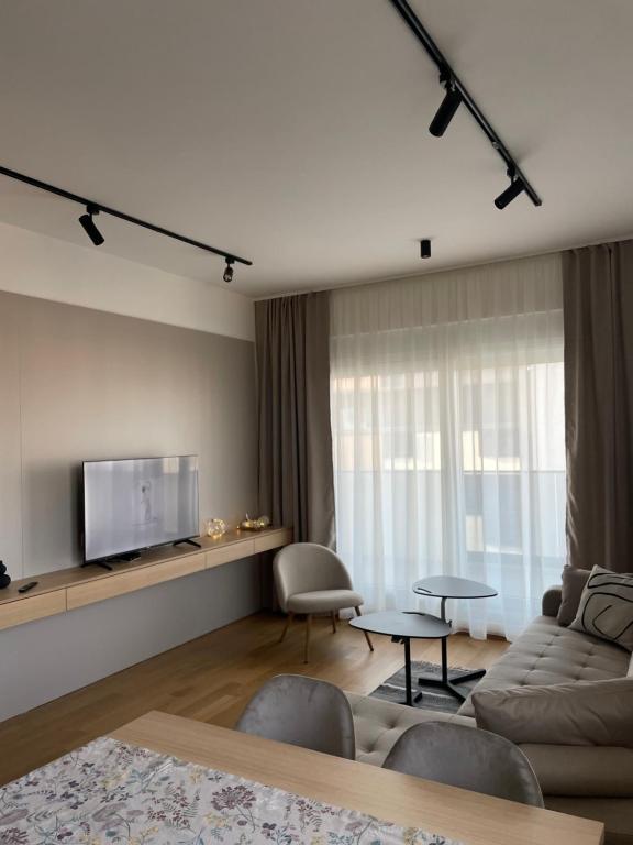 a living room with a couch and a tv at Apartment ALPHA in Banja Luka