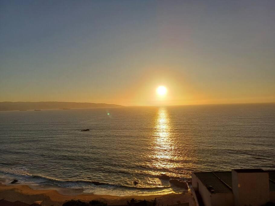 a sunset over the ocean with the sun in the sky at Departamento El Encanto - Reñaca in Viña del Mar