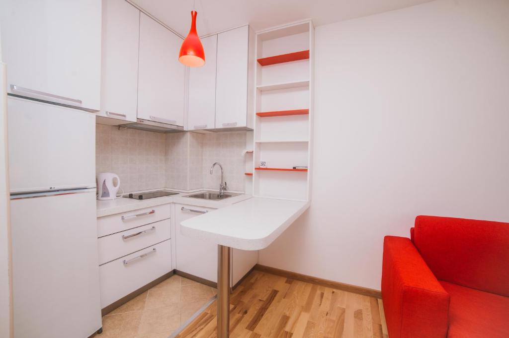 een keuken met een wastafel en een rode stoel bij Apartment DV Magnolia in Tivat