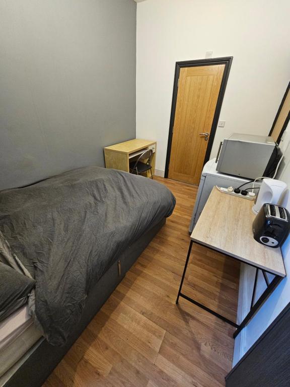 a small room with a bed and a desk with a printer at Double en suit room in Levenshulme (2) in Manchester