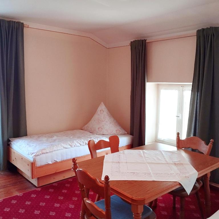 a bedroom with a table and a bed and a table and chairs at Beim Haasen in Grabenstätt