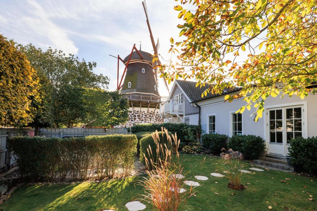 a house with a windmill in the back yard at Gamla Viken, 63 kvm - 152 kvm, 4-6 bäddplatser, Möllarevägen 5, Viken in Viken