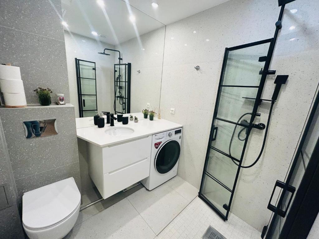 a bathroom with a washing machine and a sink at Apartment Targowa L8 in Lublin