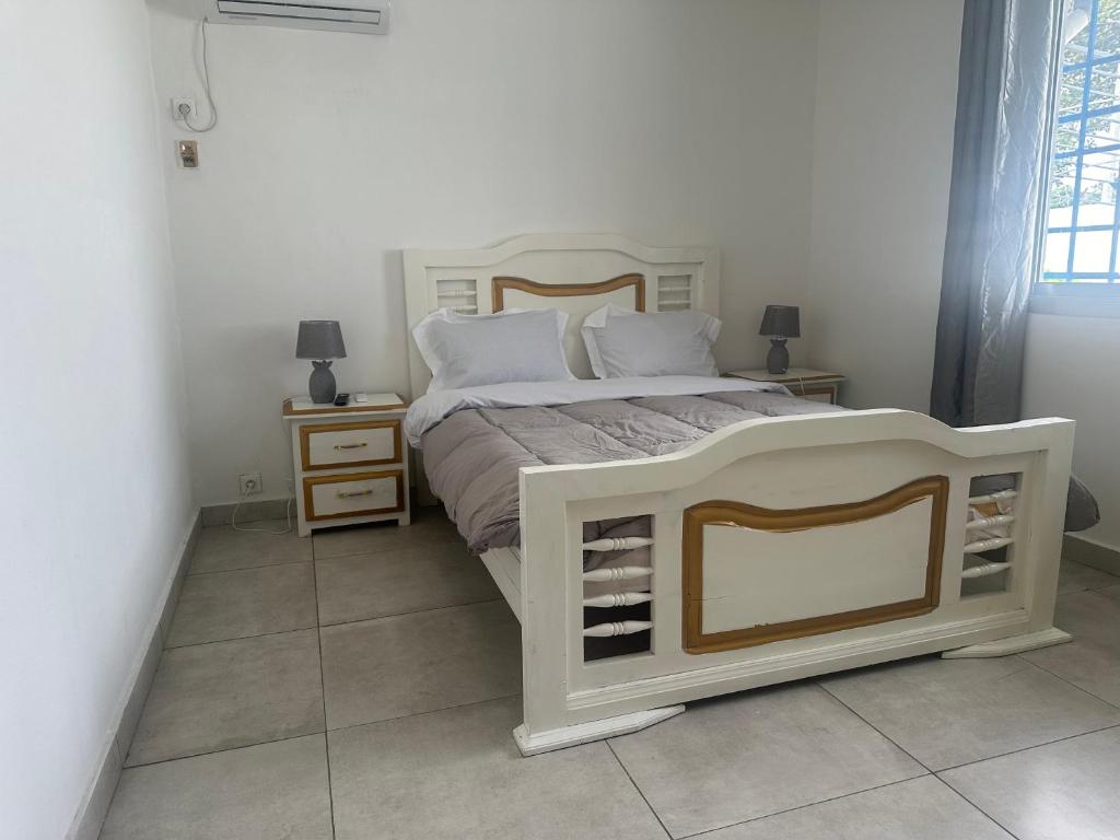 een slaapkamer met een wit bed en 2 nachtkastjes bij Villa bord de mer louis in Libreville