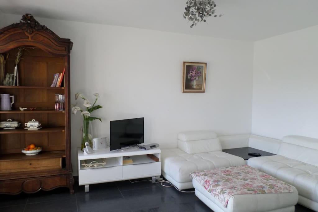 un salon avec un canapé blanc et une télévision dans l'établissement T3 Tout confort-20 min à pied plage, à Fréjus