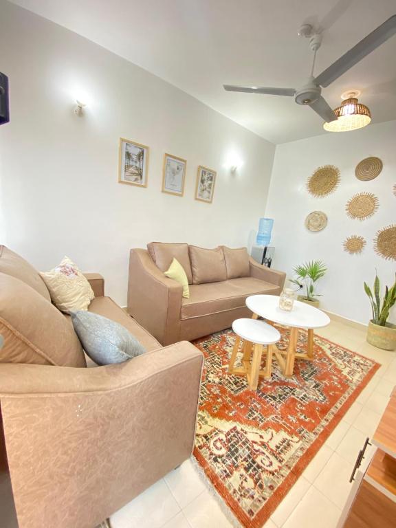 a living room with a couch and a table at MASKANI COSY APARTMENT - Nyali, Mombasa. in Mombasa