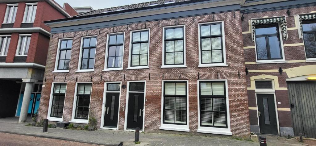 a brick building with many windows on a street at Top Bed and Breakfast in Sneek