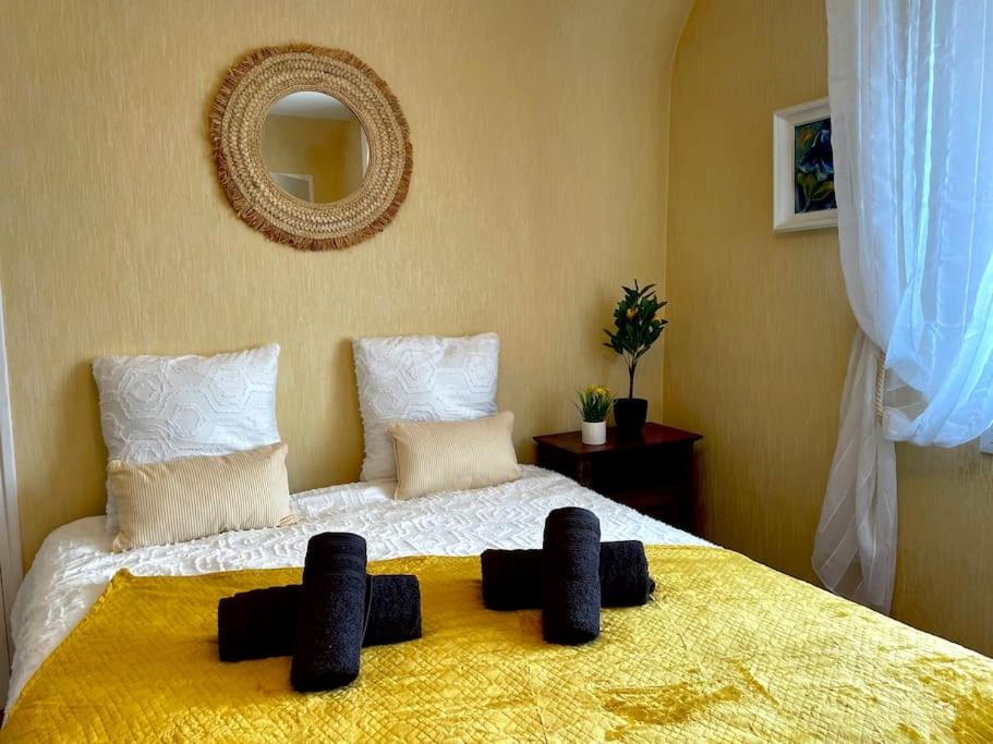 - une chambre avec un grand lit et une couverture jaune dans l'établissement Résidence des Rhodos, proche Lorient, à Caudan