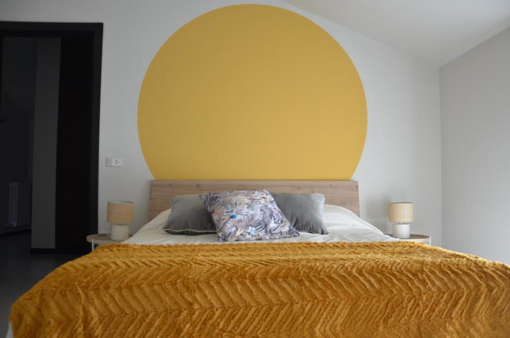 a bed with a yellow headboard and two pillows on it at Casa Framama in Piobesi dʼAlba