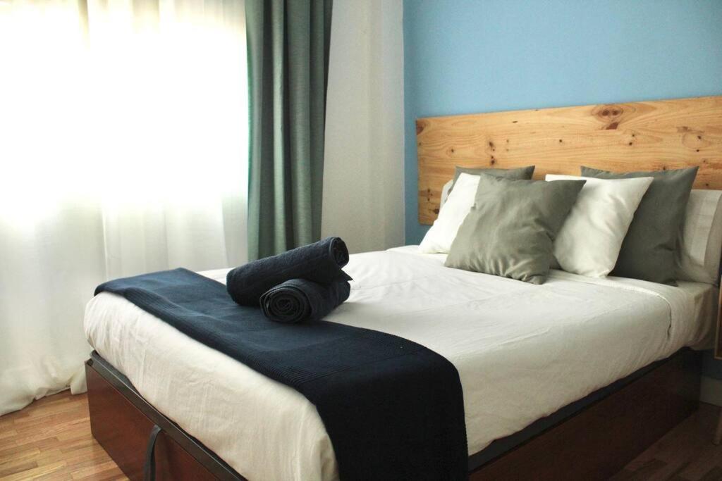 a bedroom with a large bed with a wooden headboard at Gran Vía-Plaza España 2 habitaciones in Madrid