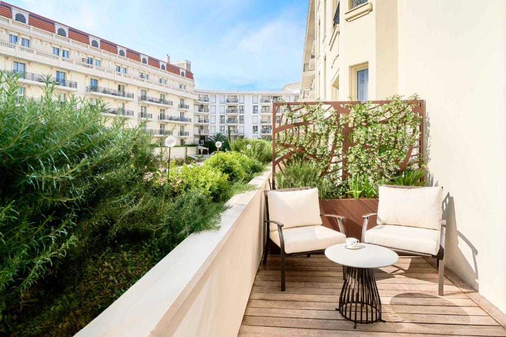 a balcony with two chairs and a table on a building at Carlton Cannes, a Regent Hotel in Cannes