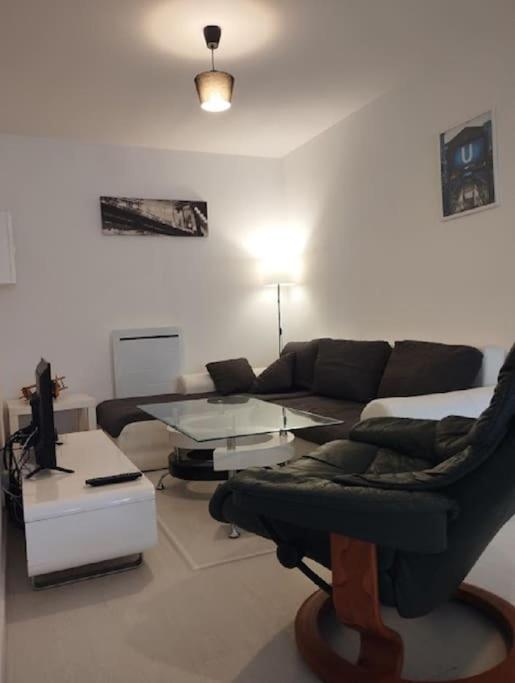 ein Wohnzimmer mit einem Sofa und einem Glastisch in der Unterkunft appartement discount sortie de Besancon LE MONTANA in Chevigney-sur-lʼOgnon