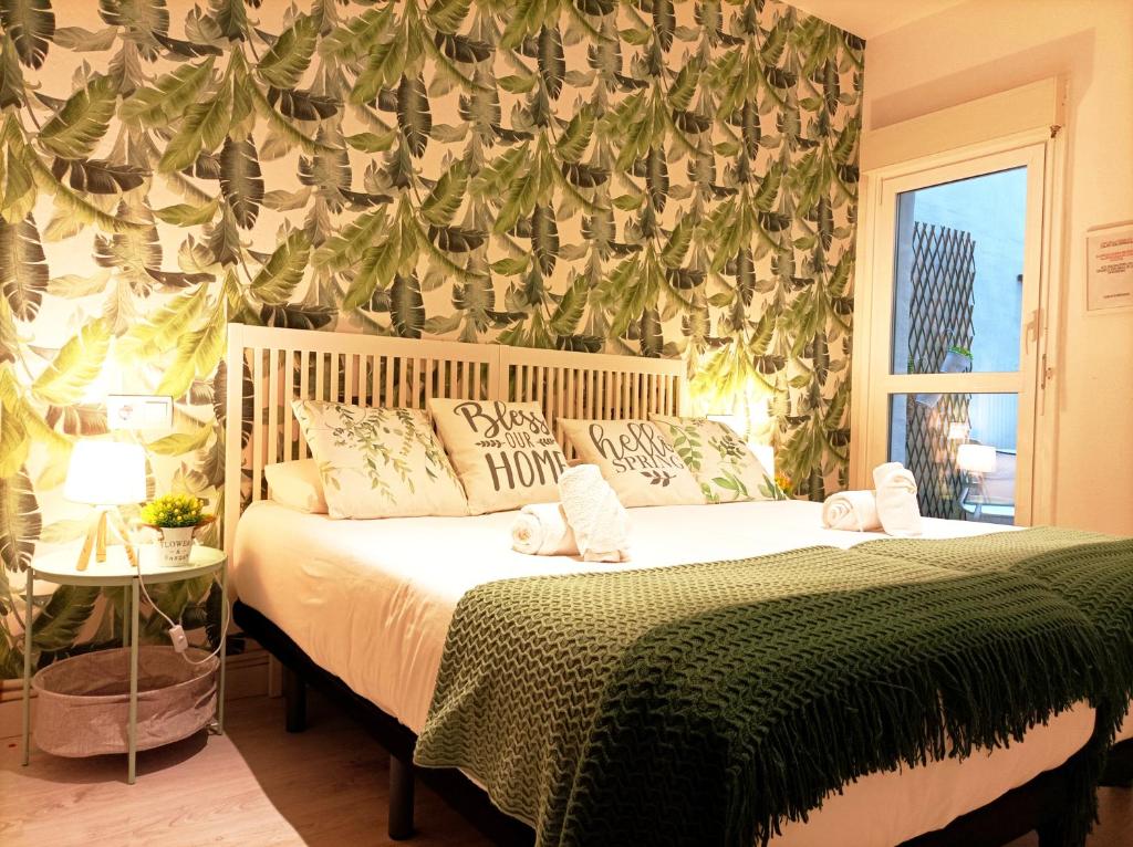 a bedroom with a bed with a green blanket at JARAUTARESORT in Pamplona