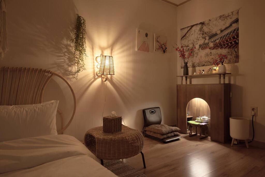 ein Schlafzimmer mit einem Bett, einem Tisch und einer Lampe in der Unterkunft Damda Stay in Seoul