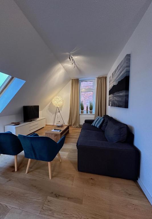 a living room with a couch and a table at Georg6 GEORG6 - Fewo 5 in Norderney