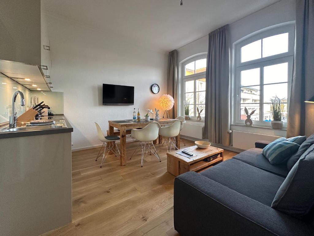 een woonkamer met een bank en een tafel en een keuken bij Georg6 GEORG6 - Fewo 4 in Norderney