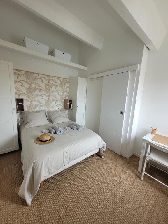 een slaapkamer met een bed met een hoed erop bij Béréa - Les Cormorans - Vue port et mer in Frontignan