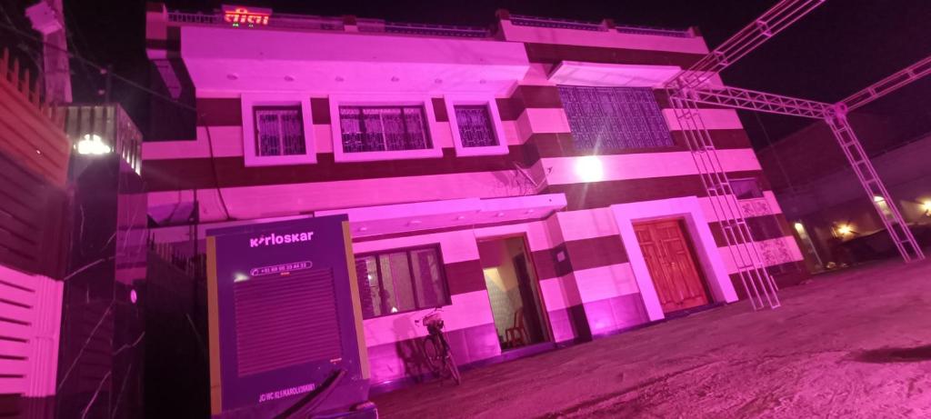 un edificio con luces rosas en el lateral. en Leela home stay, en Faizābād