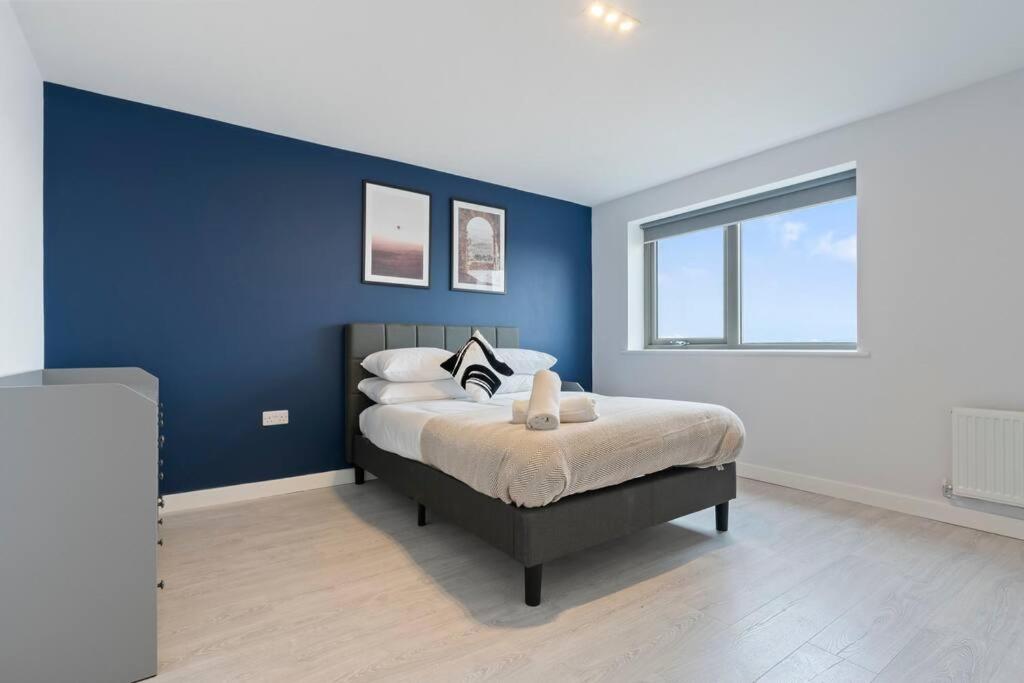 um quarto com paredes azuis e uma cama com almofadas em Exquisite 7 Bedroom 5.5 Bathroom House - Over 1900 sqft - Close to City Centre with Free Parking, Fast W-Fi and SmartTVs by Yoko Property em Northampton