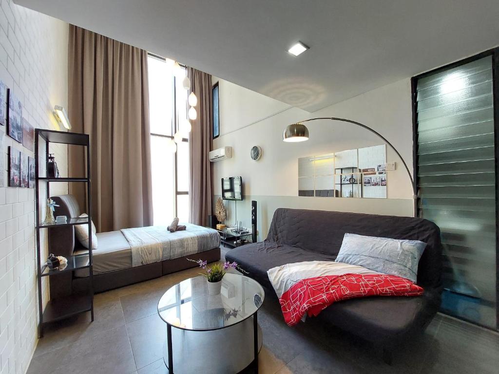 een woonkamer met een bank en een bed bij Inspired Homes, Empire Duplex#1 in Petaling Jaya