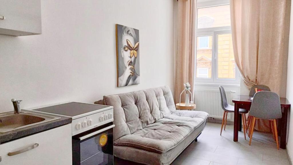 a kitchen and living room with a couch and a stove at Family Apartment MZ27 in Vienna