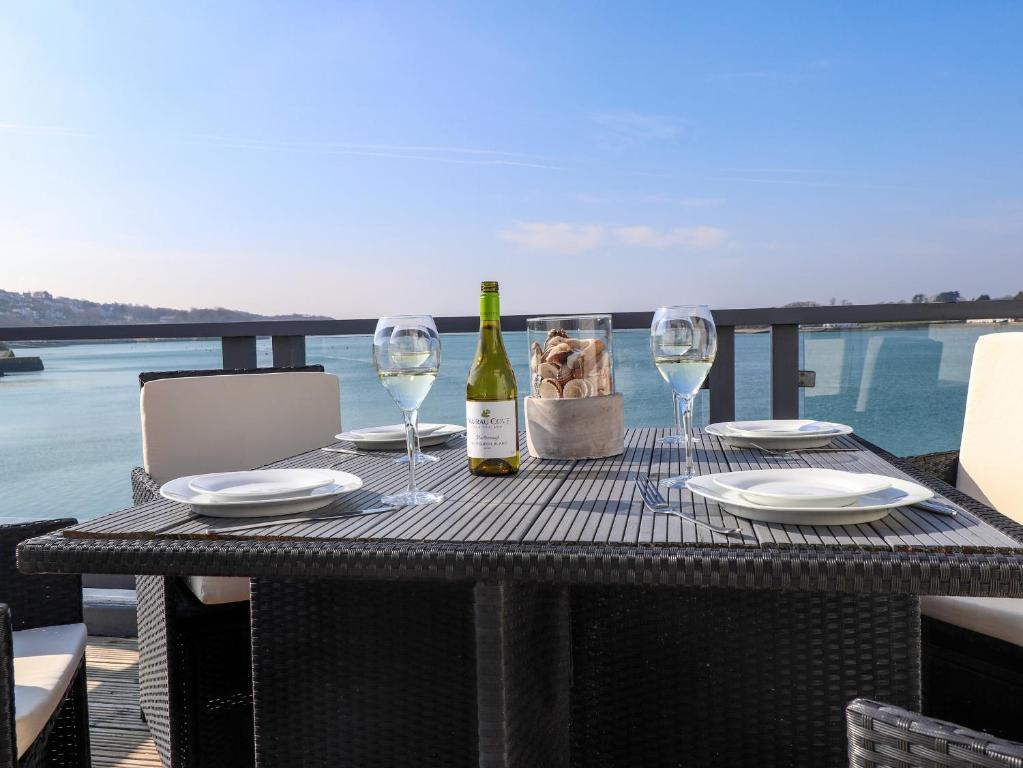 una mesa con dos copas y una botella de vino en White Sails en Y Felinheli