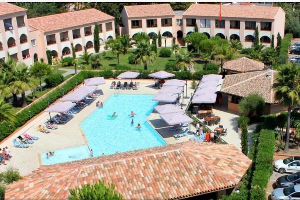 une vue aérienne d'une piscine dans un complexe hôtelier dans l'établissement appartement bord de mer en Corse avec 2 piscines 100 metres de la plage, à Linguizzetta