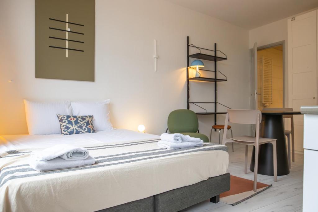 Smartflats - L'Orangerie I Maastricht في ماستريخت: غرفة نوم بسرير وطاولة وكراسي