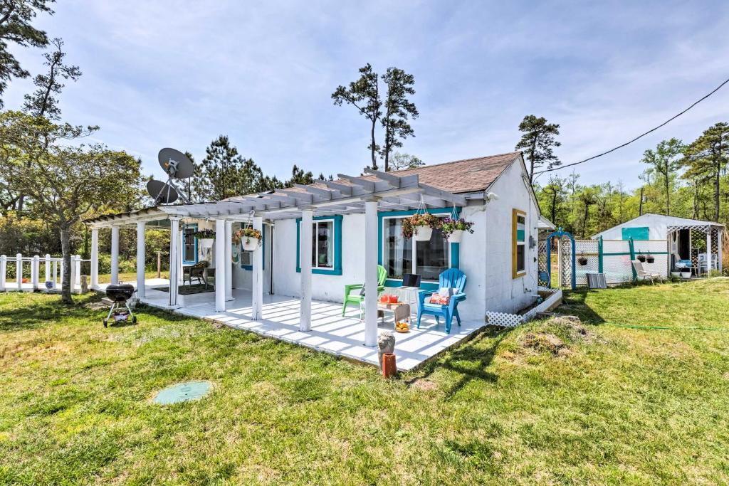 une petite maison blanche avec une terrasse dans une cour dans l'établissement Oceanfront White Stone Cottage with Private Beach!, à White Stone